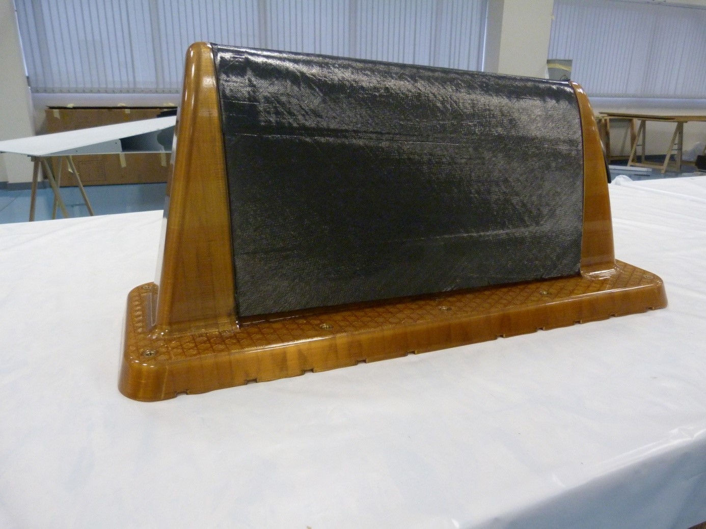 The tooling made by additive manufacturing in Ultem 1010 resin, amber color, covered with a conductive carbon fiber fabric preform.